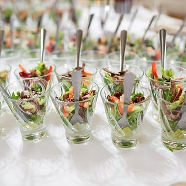 Glasses with salad served on white table